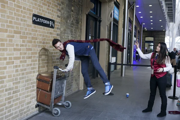 Kings Cross istasyonuna duvar fotoğraf için Harry Potter hayranları tarafından ziyaret için platform dokuz üye ve üç çeyrek ile trolley. Eğlenceli onun arkadaşı alarak resim jumping
