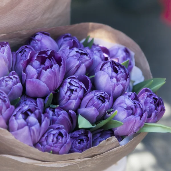 Ramos de tulipanes azules en papel artesanal en paquete de papel —  Fotos de Stock