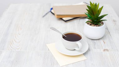 Boş not defteri, kahve fincanı ve tahta kalemi olan masa. Düz görünüm kopyalama alanı.