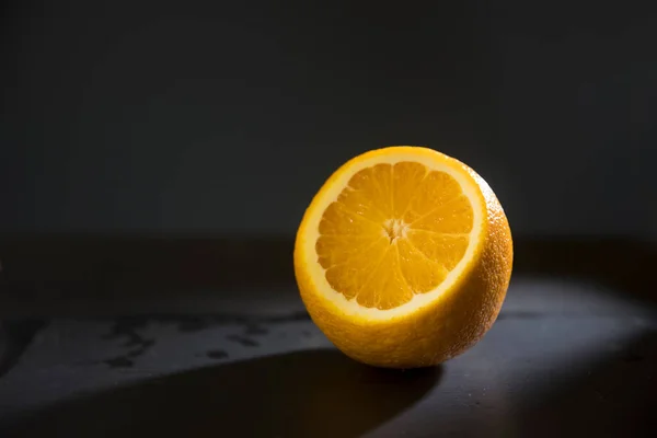Een Halve Sinaasappel Een Smalle Balk Een Zwarte Achtergrond Reflectie — Stockfoto