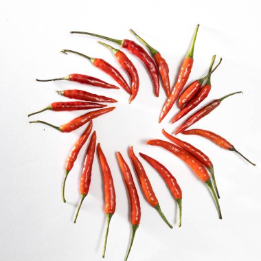 Çemberde beyaza izole edilmiş bir sürü kırmızı minyatür biber var. Boşluğu kopyala.