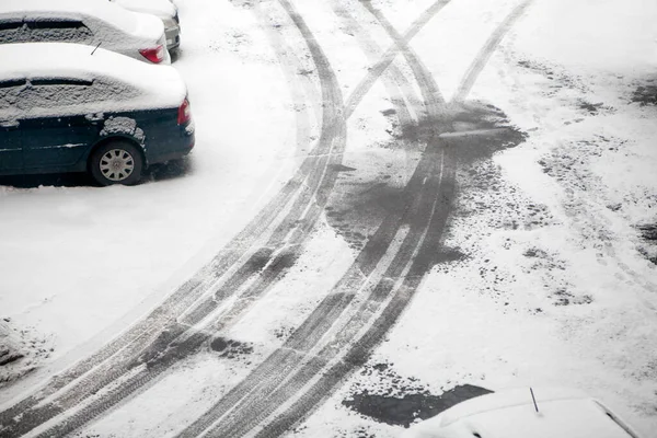 最初の雪だ アスファルトの上に車を渡すの痕跡 冬が来る — ストック写真