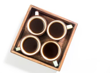 Mango ahşap tepside beyaz arka planda dört espresso fincanı var. Boş boşluk