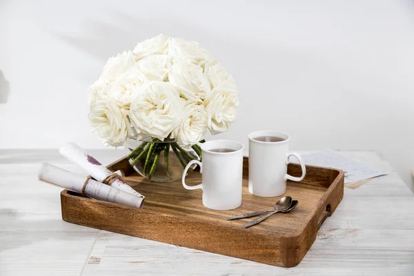 Bukiet Białych Róż Okrągłym Szklanym Wazonie Tacy Dwoma Filiżankami Herbaty — Zdjęcie stockowe