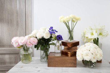 Beyaz güller, pembe ranunculus, mavi şakayıklar, sarımsı düğün çiçekleri, özel bir mutfak dekorasyonu için masanın üstünde zambaklar. Boşluğu kopyala