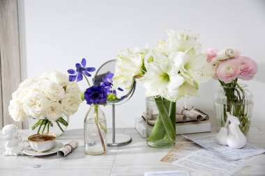 Beyaz güller, pembe ranunculus, mavi şakayıklar, sarımsı düğün çiçekleri, özel bir mutfak dekorasyonu için masanın üstünde zambaklar. Boşluğu kopyala