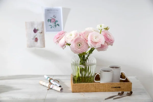 Bukiet Różowych Perskich Jaskrów Szklanym Wazonie Tacy Dwoma Filiżankami Kawy — Zdjęcie stockowe