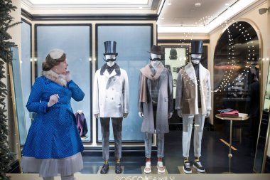 Moskova, Rusya -30 Aralık 2020, mavi benekli pelerinli kadın ve beyaz kürk şapka, retro tarzı. GUM mağazasının Noel süslemesi). Erkek bıyıklı mankenlerin olduğu bir gösteri.