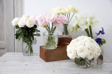 Beyaz güller, ranunculus, mavi şakayıklar, sarımsı düğünçiçekleri, ahşap kutuların üzerindeki nilüferler, mutfak dekorasyonu için özel bir durum..