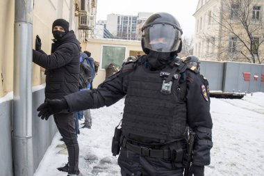 Moskova, Rusya - 31 Ocak 2021, Rusya 'daki toplu protestolardan Aleksey Navalny' nin salıverilmesi istendi. Polis barışçıl protestocuları duvara yasladı ve ellerini kaldırttı..