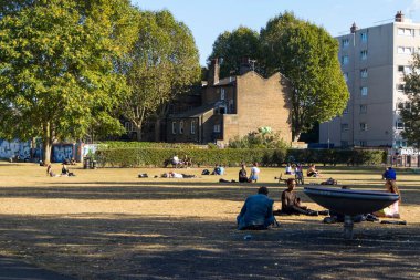 Londra, İngiltere - 29 Eylül 2020, Allen Gardens Break Lane yakınlarında küçük bir park. Yerel halk çimlerin üzerinde oturuyor.