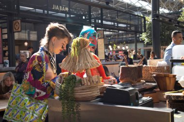 Londra, İngiltere - 20 Eylül 2020, Spitalfields Antic Market Alışveriş Merkezi. Parlak giyimli insanlar gıda pazarından yiyecek alıyorlar.