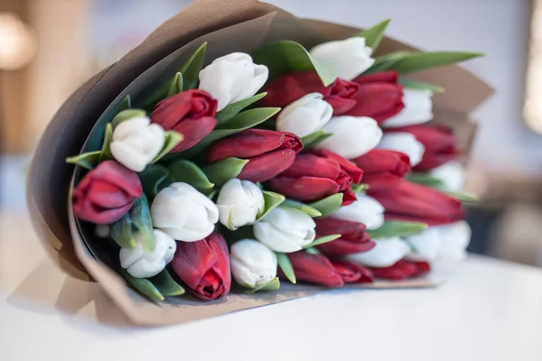 Sobre Mesa Hay Ramo Tulipanes Blancos Rojos Oscuros Envueltos Papel — Foto de Stock