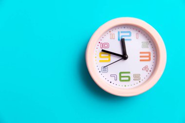 Mavi arka planda yuvarlak bir saat var. Uzayı kopyala On ikiye on var.