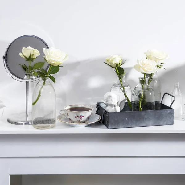 白い暖炉のコンソールにガラスの形の花瓶に白いバラの花束 内部装飾として天使の信仰の置物 コピースペース ローズホワイトピンク Hara — ストック写真