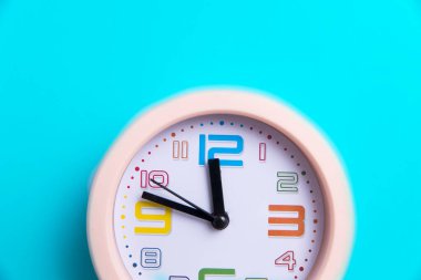 Mavi arka planda yuvarlak bir saat var. Uzayı kopyala On ikiye on var.