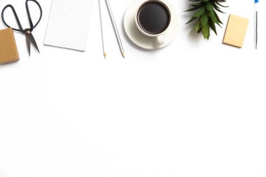 Not defteri, not kağıdı, makas, kalem, sulu bitki ve beyaz bir masada bir fincan kahve. Boşluğu kopyala