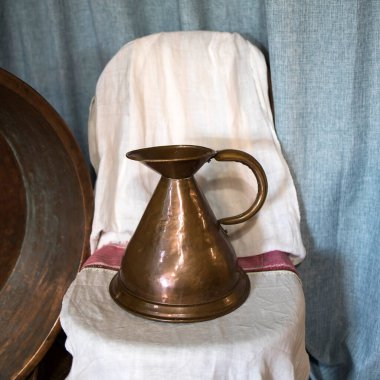 Sıra dışı bir 19. yüzyıl bakır testisi bir sandalyenin üzerinde duruyor.