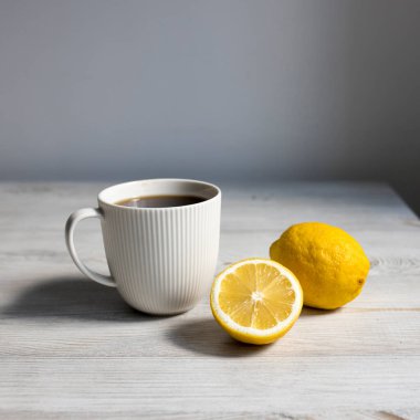 Minimalist İskandinav tarzı. Masadaki tepside bir fincan kahve ya da çay. Limon ve kaşık