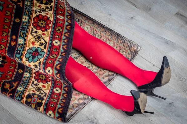 Red Female Legs Torn Tights Stick Out Carpet — Stock Photo, Image