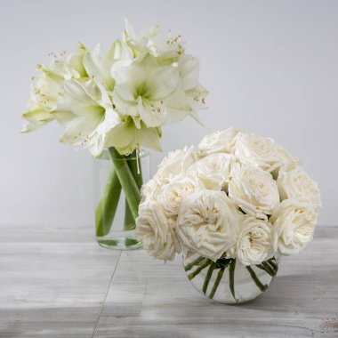 Beyaz güller, masanın üstünde yuvarlak vazolar var. Özel bir durum için mutfak süsü olarak. Uzayı kopyala Kare kare