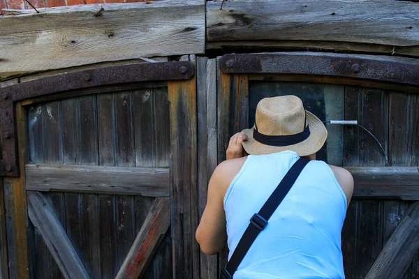 Девушка Голубой Рубашке Соломенной Шляпе Заглядывает Трещину Двери Старого Сарая — стоковое фото