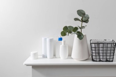 Okaliptüs dallı bir vazo, plastik şampuan şişeleri, krema. Tuvalette. Mesaj için yer var. Yüzü yuvarlanmış metal bir sepet.