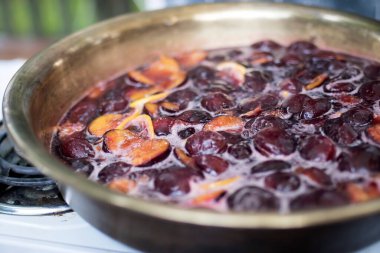 Gaz ocağında limonlu erik reçeli ve baharat pişirmek. Geniş çerçeve