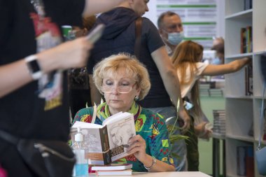 Moskova, Rusya - 21 Haziran 2021, Kitapçıda kitap okuyan yaşlı kadın