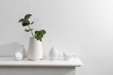 Bir kuşun figürleri çekmece sandığının yüzeyindedir. Okaliptüs dallı bir vazo. Tuvalette. Metin için boşluk