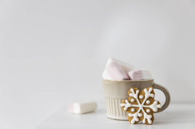 Noel ya da yeni yıl kompozisyonu, kakao, zencefilli kurabiye ve Noel süslemeleri. Masanın beyaz arka planında kremalı sıcak çikolata. Uzayı kopyala Model