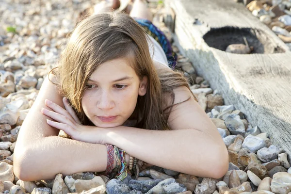 Nachdenkliches Mädchen am Strand liegend — Stockfoto