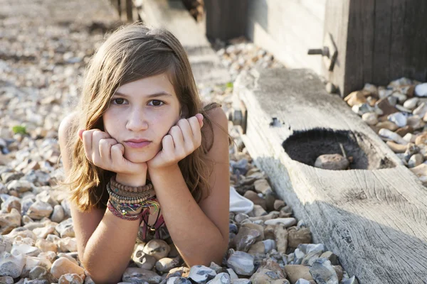 Pensive girl lying on the beach — Stock Photo, Image