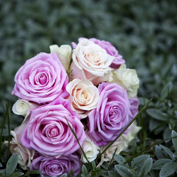 Buquê de casamento de rosas rosa e branco deitado na grama — Fotografia de Stock