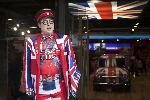 LONDRA - 18 OTTOBRE: Il venditore indossa un'uniforme che simboleggia la bandiera inglese all'ingresso del negozio Cool Britannia. 18 Ottobre 2014 a Londra, Inghilterra, Regno Unito . — Foto Stock