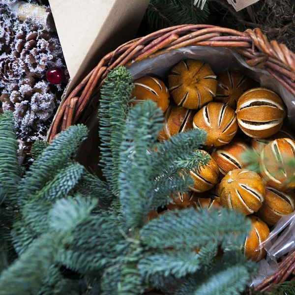 Arancio secco nel cestino. Ghirlanda di abete di Natale decorata con fiori artificiali — Foto Stock