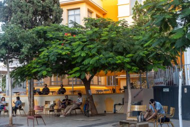 Tel Aviv, İsrail, 28 Ekim 2025, Bialik Meydanı. Alger 's Cafe Şehirde Açılıyor. İnsanlar beyaz şemsiyeler altında içiyor ve sohbet ediyorlar..