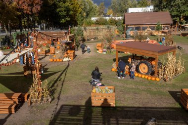 Varşova, Polonya, 2 Ekim 2025, Tom Amca 'nın Çiftliği. Kabak tarlası ya da sonbahar festivali düzeneği, tezgahlar, kabaklar, kurutulmuş mısır sapları, kapalı bir traktör görüntüsü ve yürüyen insanlar..