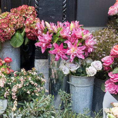 Burgonya zambakları, ortanca çiçekleri, kırmızı anemonlar, düğünlerde, romantik etkinliklerde veya anma törenlerinde iç dekorasyon için uygun okaliptüs dallarıyla aksanlı turuncu güller içeren bir çiçek aranjmanı..