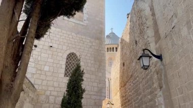 Kudüs, İsrail, 9 Ekim 2025, Zion Dağı 'ndaki görkemli Dormition Manastırı eski şehrin dar bir sokağında eski fenerler ve kaldırım taşından bir sokak ile görüldü..