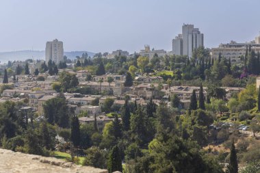 jerusalem, Israel, 2 November 2025, A panoramic view of a neighborhood, showing densely packed traditional stone houses with tiled roofs interspersed with cypress trees 