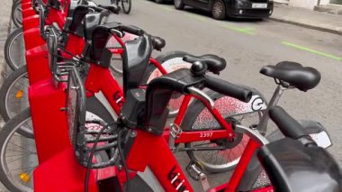 Varşova, Polonya, 5 Eylül 2025 Kiralık kırmızı bisikletliler, yoldan geçen bulanık bir bisikletçiyle.