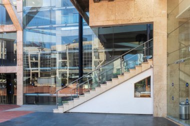 Tel Aviv, İsrail, 5 Temmuz 2025, Tel Aviv Sanat Müzesi, çevresindeki habima tiyatrosunun mimarisini yansıtan cam duvarları ve korkulukları olan modern bir merdivenin yakın çekimi olan seçkin bir kültür kurumudur..