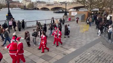 Londra, İngiltere, 6 Aralık 2025 Noel Baba kılığında insanlar kalabalık ve Noel pazarları arasında Güney Şeria boyunca yürüyorlar..