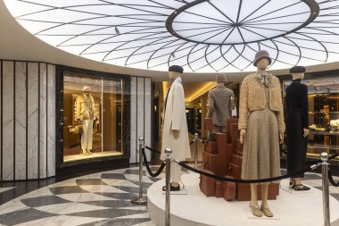 Londra, İngiltere, 7 Aralık 2025, şık, eski moda giysiler giyen mankenler mermer döşeme ve aydınlatılmış geometrik tavan özelliğine sahip lüks bir mağazada sergileniyor. Harrods Mağazası