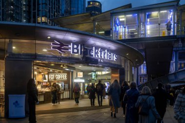 Londra, İngiltere, 2 Aralık 2025, Blackfriars istasyonunun aydınlık girişine doğru yürüyen bir grup insan.