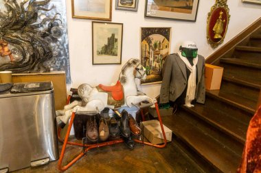 Londra, İngiltere, 2 Aralık 2025, sallanan at resimleri ve polis kaskı olan bir ikinci el dükkanının eklektik köşesi..