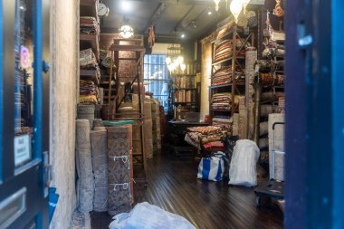 Depo odası geleneksel doğu halıları ve ahşap bir kütüphane merdiveniyle dolu..