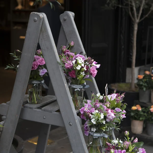 Bouquet von Erbsen, Lathyrus odoratus, Blüten in einer lila Vase stehend — Stockfoto