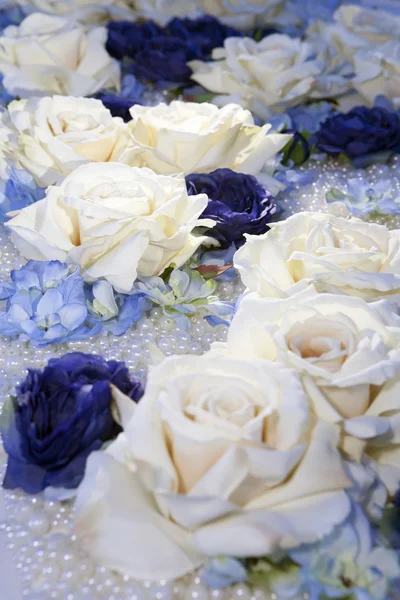Искусственные белые и голубые розы на жемчужных бусах — стоковое фото